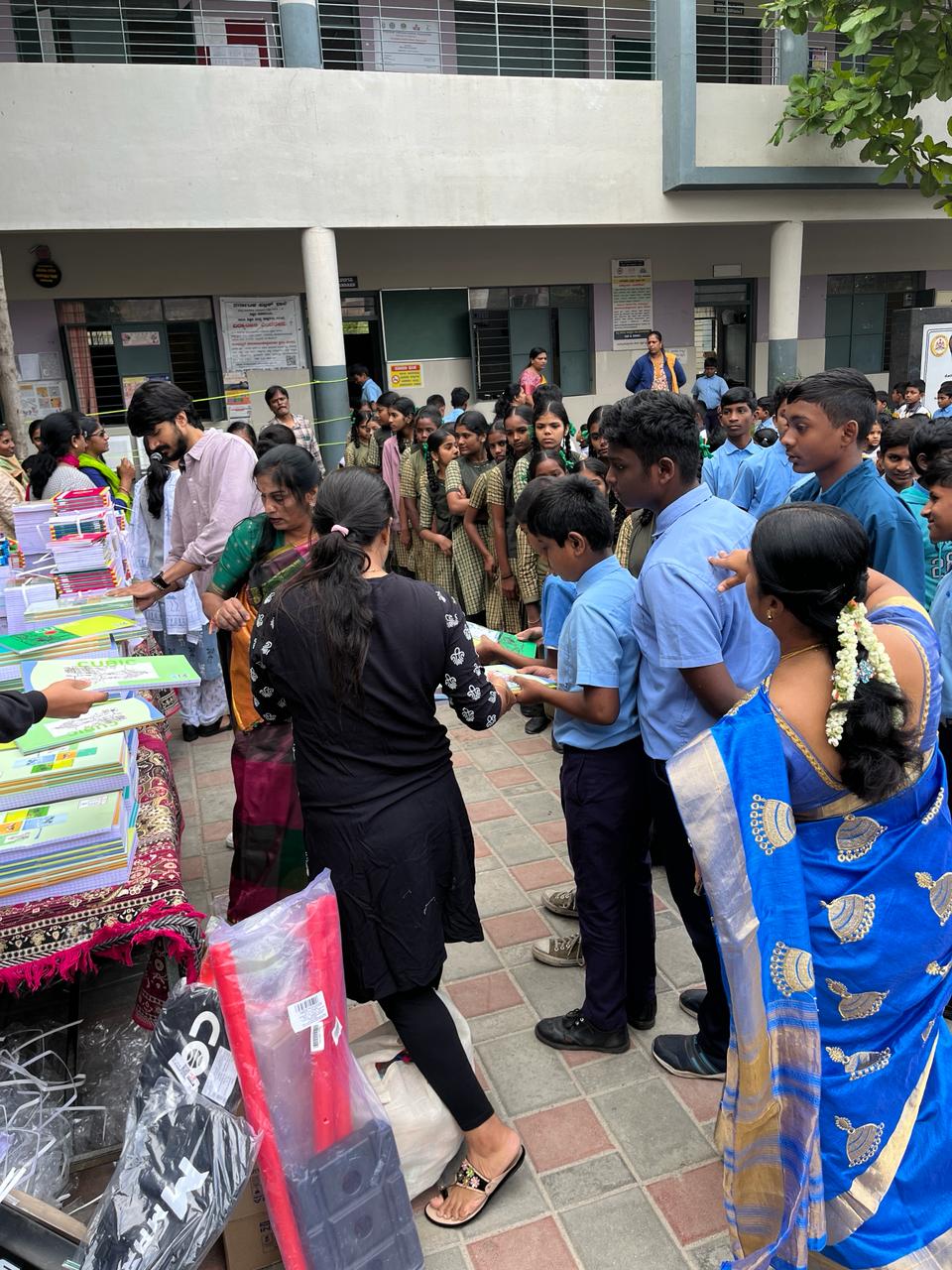 Students lining up to receive free notebooks at school.