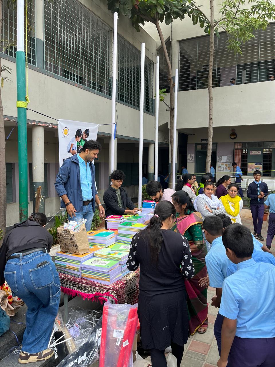 Staff and volunteers distribute educational notebooks to school children.